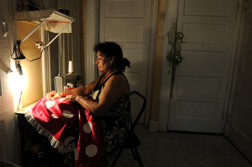 New York, United States. Doña Berta,55,from Mexico repairs her Minnie Mouse costume at her house in New Jersey. 2013 ©Joana Toro.