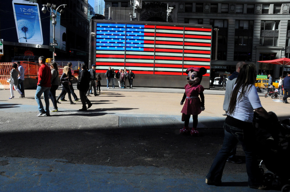 New York, United States. Immigrants dressed up as Minnie Mouse ask for donations after posing for pictures in Times Square in New York, 2013. ©Joana Toro.