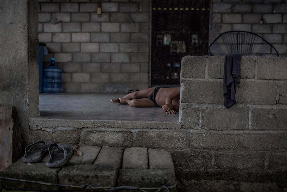 Jose Maria Morelos, Oaxaca, August 22nd,2014: A boy plays on the floor of his house in José Maria Morelos, Oaxaca. This isolated village is named for an independence hero, thought to have had black ancestors, who helped abolish slavery in Mexico. It lies in the rugged hills of southwestern Mexico, among a smattering of towns and hamlets that have long embraced a heritage from African slaves who were brought here to work in mines and on sugar plantations in the 16th century. Photograph by © Adriana Zehbrauskas